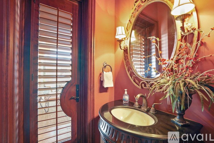 A bathroom with a round sink and a mirror above it.