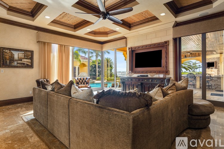 A living room with a brown couch and a ceiling fan.