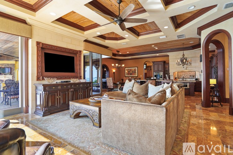 A living room with a couch, a television, and a chandelier.