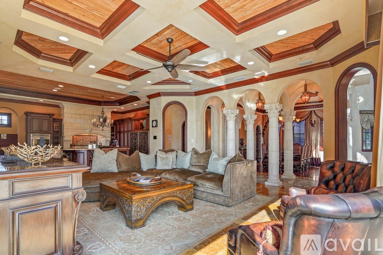 A living room with a wooden ceiling and a large couch.