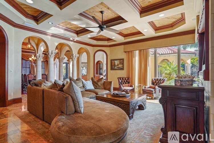 A living room with a brown couch and a fan on the ceiling.