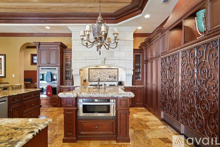A kitchen with a granite countertop and a chandelier.