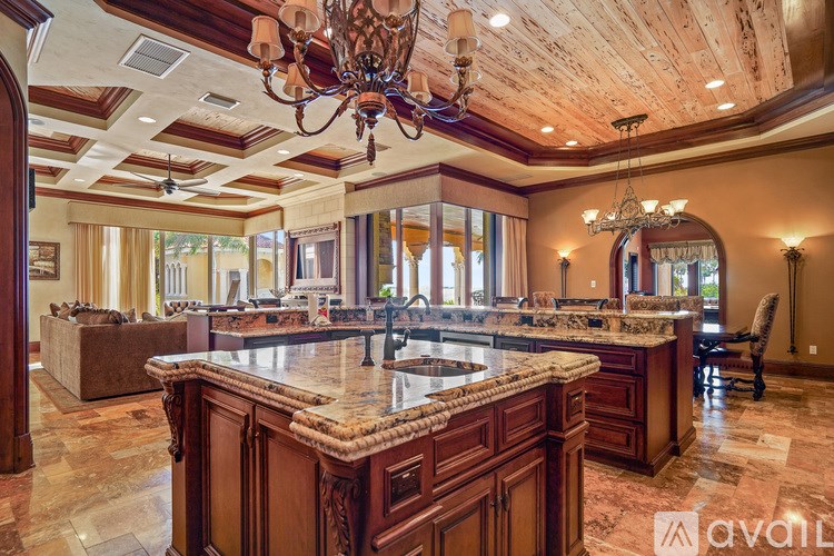 A large, luxurious kitchen with a center island and a chandelier.