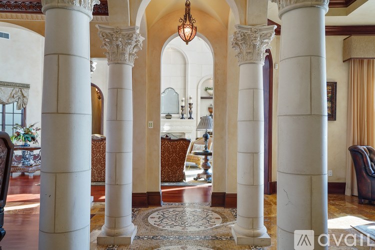 A large room with a carpet and columns.