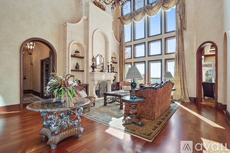 A large, ornate table sits in the middle of a spacious room with high ceilings and arched windows.