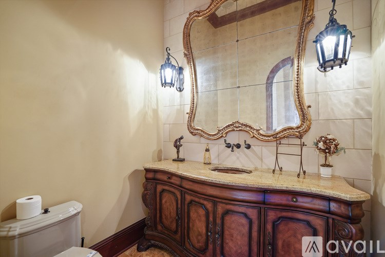 A bathroom with a wooden vanity and a mirror above it.