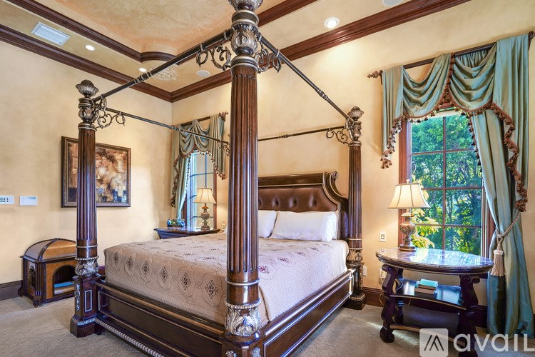 A large bed with a canopy and a footstool is in the center of the room.