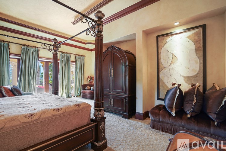 A bedroom with a large bed and a brown couch.