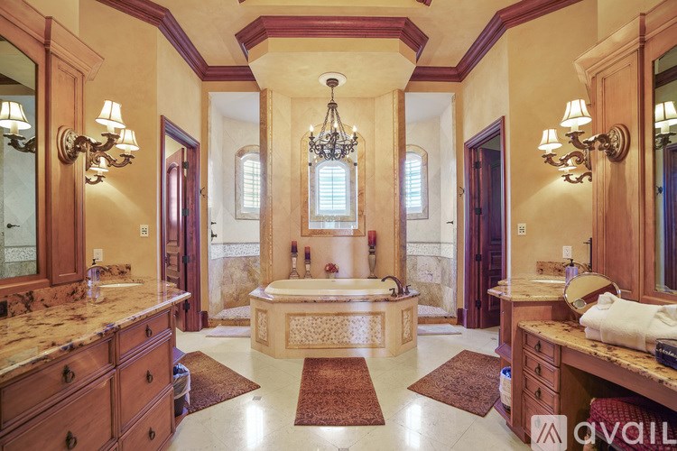 A large, luxurious bathroom with a marble countertop and a chandelier hanging from the ceiling.