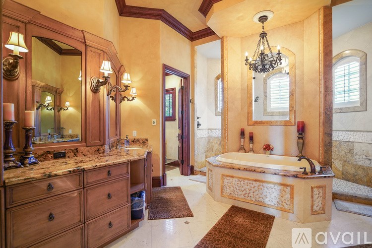 A bathroom with a marble countertop and a chandelier.