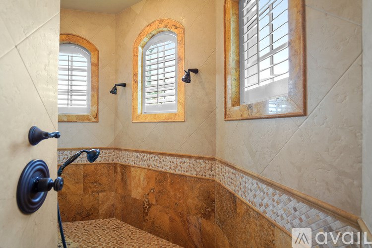 A bathroom with a brown tiled floor and a window.