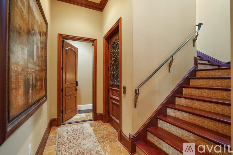 A hallway with a staircase and a door.