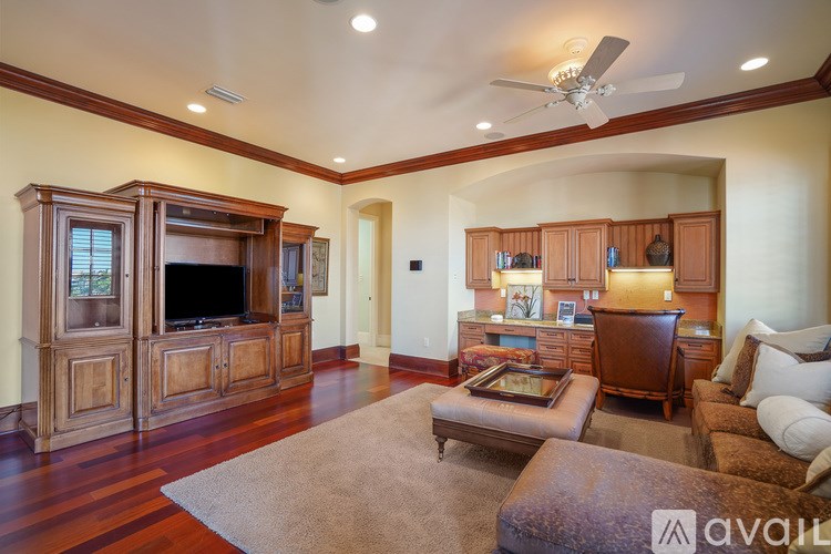 A living room with a brown rug and a wooden cabinet.