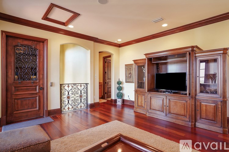 A living room with a wooden floor and a television.