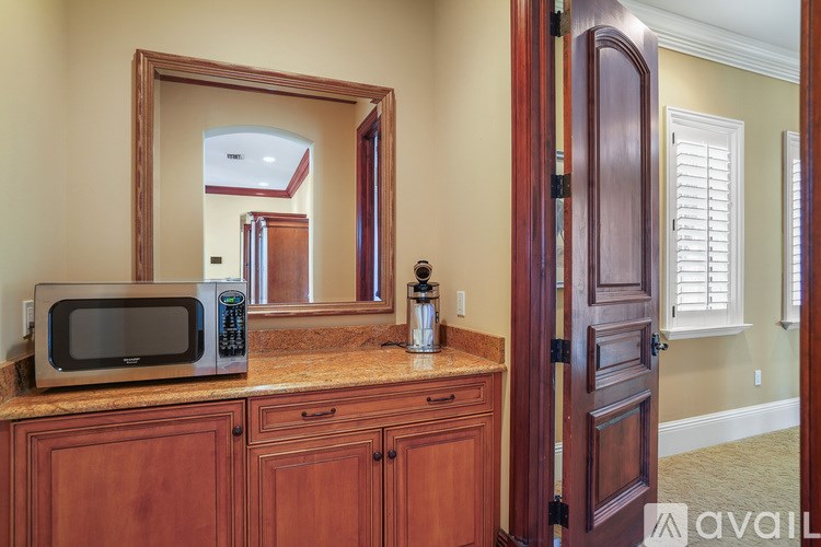 A kitchen with wooden cabinets and a microwave on top.