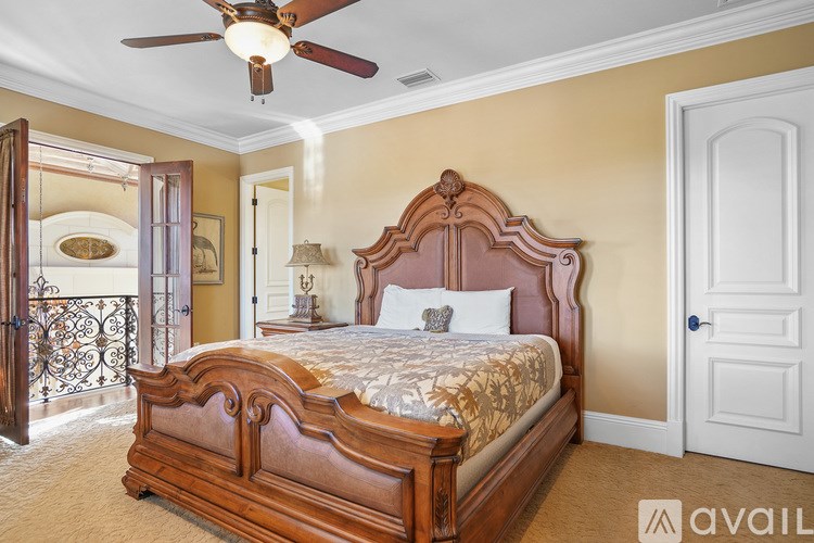 A bedroom with a large bed and a ceiling fan.