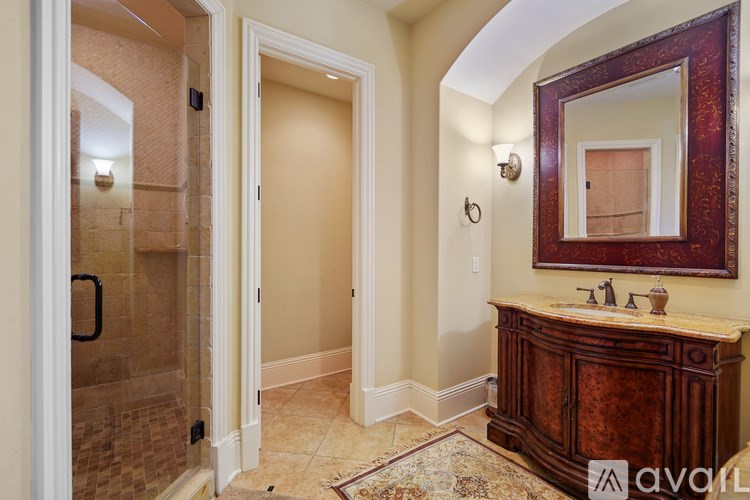 A bathroom with a wooden vanity and a mirror above it.