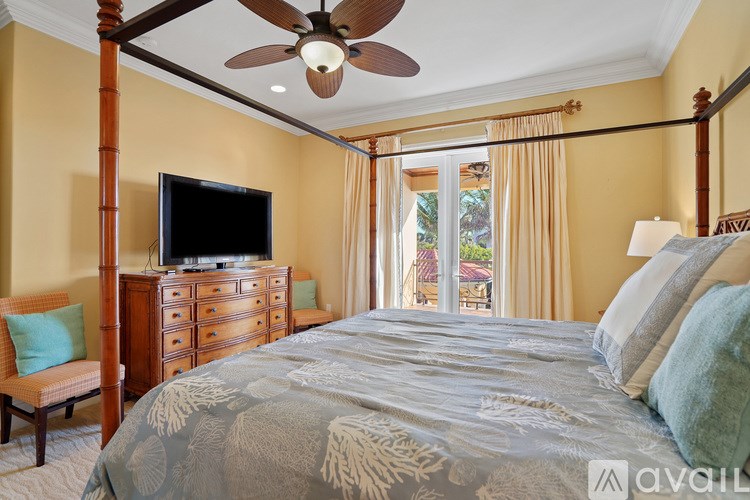 A bedroom with a bed, dresser, and television.