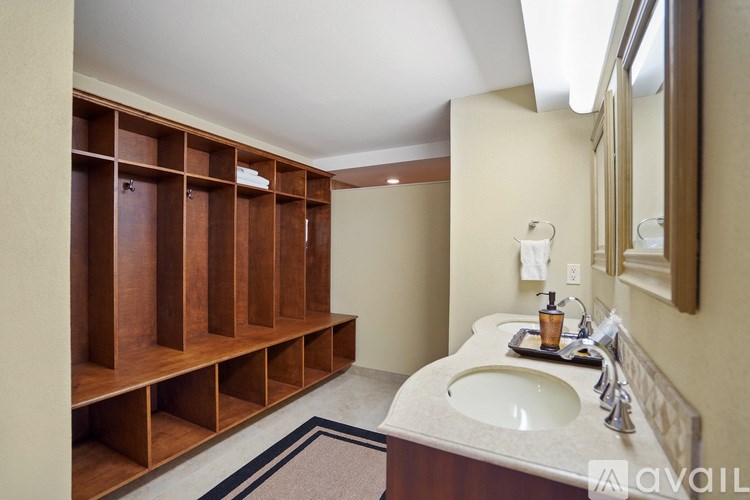 A bathroom with a sink, mirror, and wooden storage shelves.