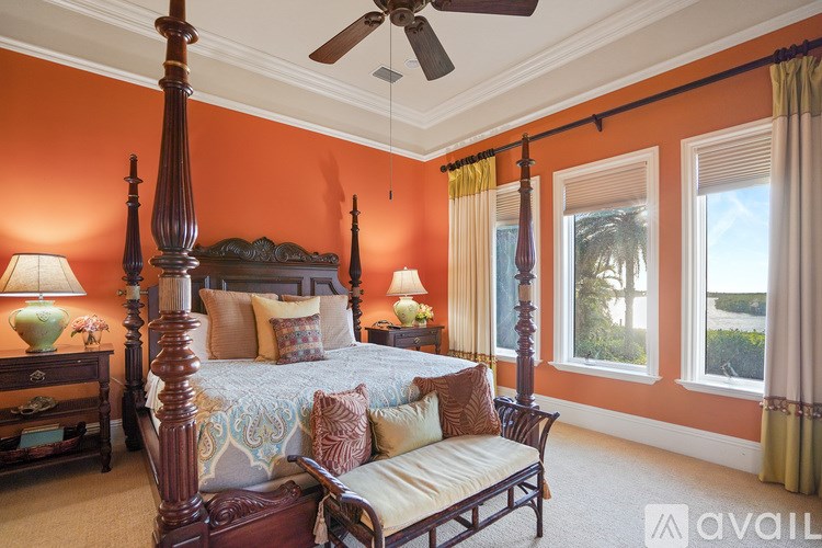 A bedroom with a four poster bed and a ceiling fan.