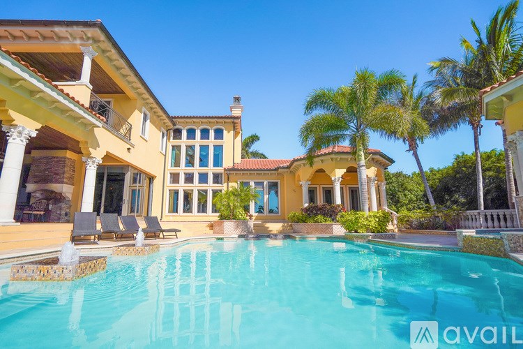 A large house with a pool in front of it.