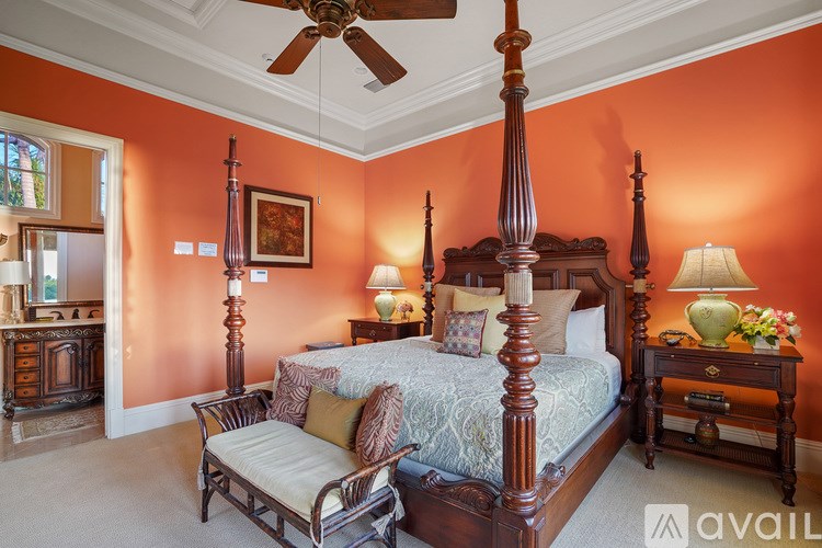 A bedroom with a four poster bed and a chair.