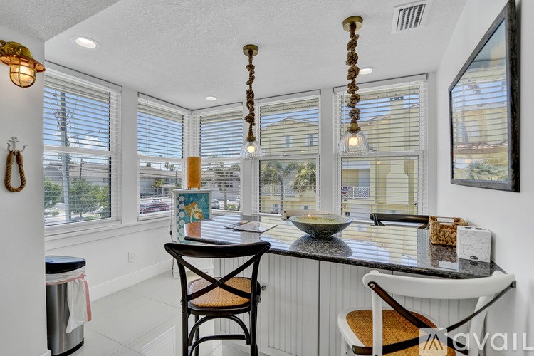 A kitchen with a table and chairs in front of a window.