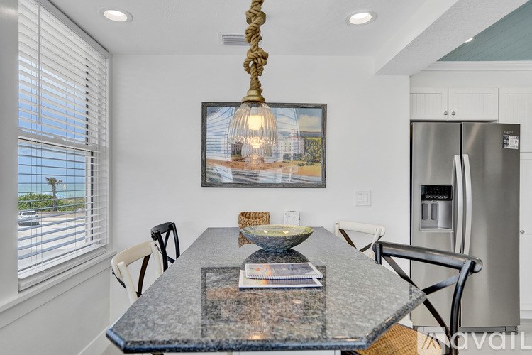 A kitchen with a granite table and a fridge.