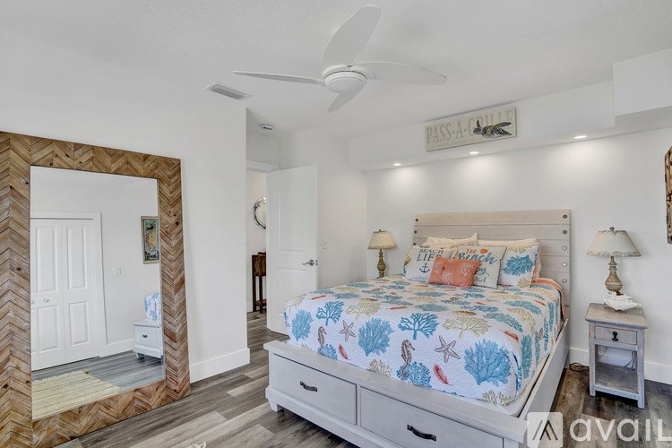 A bedroom with a large bed and a mirror on the wall.