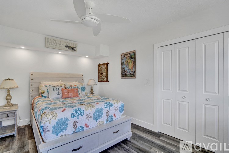 A bedroom with a large bed and a ceiling fan.