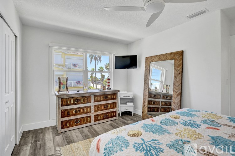 A bedroom with a bed, dresser, and a mirror.
