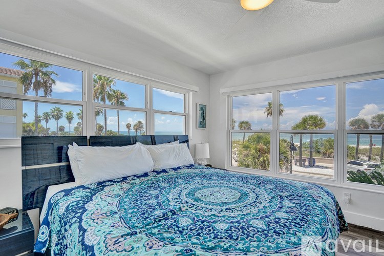 A bedroom with a bed and a view of the beach.