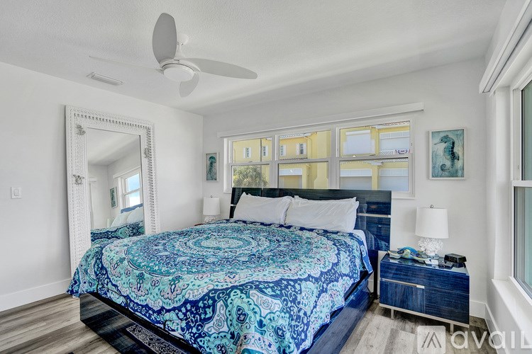 A bedroom with a large bed and a mirror on the wall.