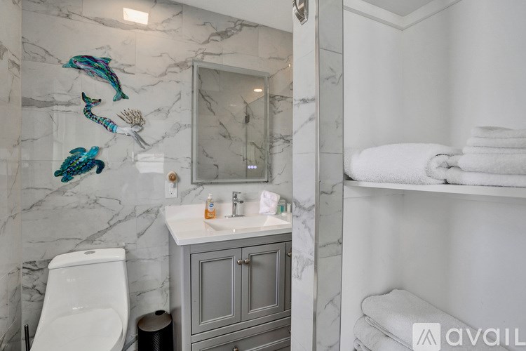 A bathroom with a marble wall and a white toilet.