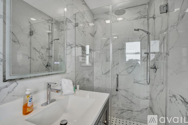 A bathroom with a marble sink and shower.