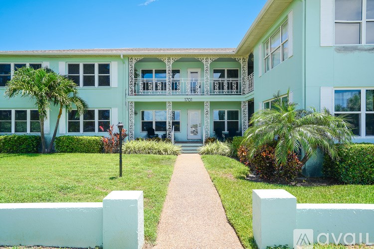 A building with a balcony and a sign that says "AVAILABLE" in front of it.
