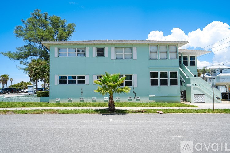 A blue building with a palm tree in front of it.