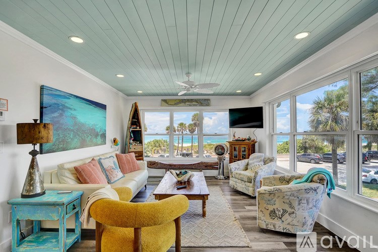 A living room with a yellow chair and a painting on the wall.