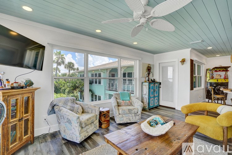 A living room with a ceiling fan and a flat screen TV.