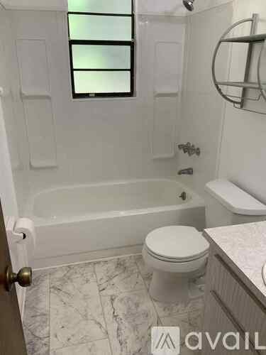 A white toilet sits next to a bathtub in a bathroom.