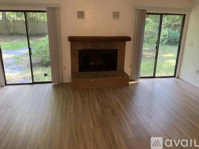 A living room with a fireplace and sliding glass doors.
