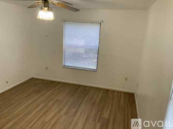 A room with wooden flooring and a ceiling fan.