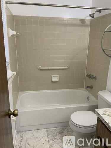 A bathroom with a toilet, tub, and shower.