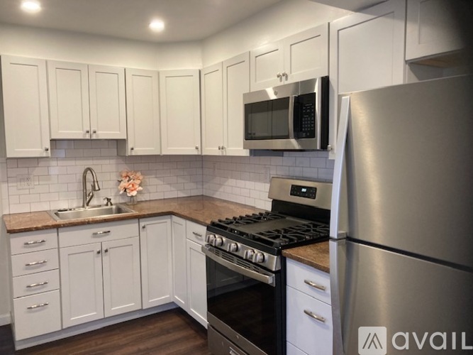 A kitchen with a refrigerator, oven, and microwave.
