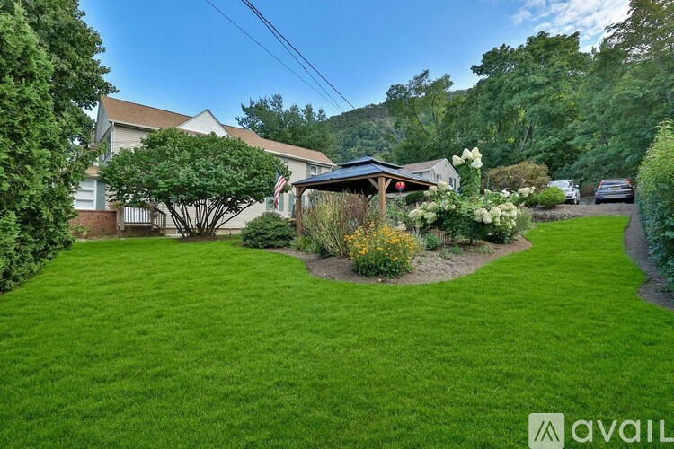 A backyard with a well-maintained lawn and a small gazebo-like structure.