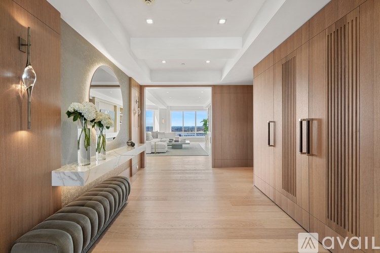 A long hallway with a bench and a vase of flowers.