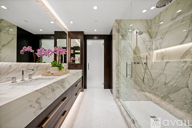 A bathroom with marble countertops and a walk-in shower.