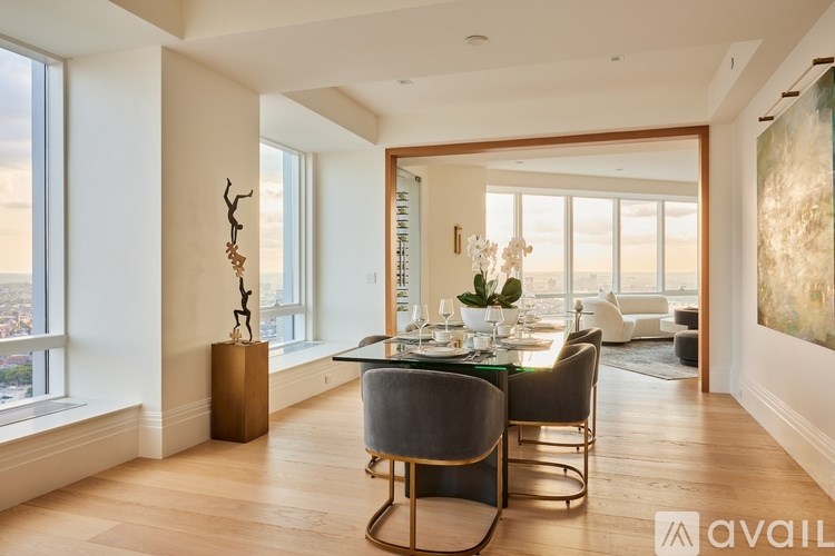 A modern dining room with a glass table and chairs.