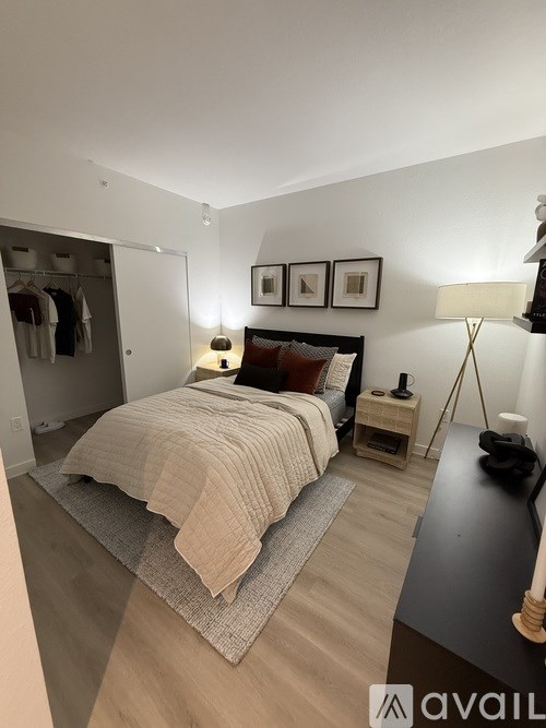 A bedroom with a bed, nightstand, and lamp.