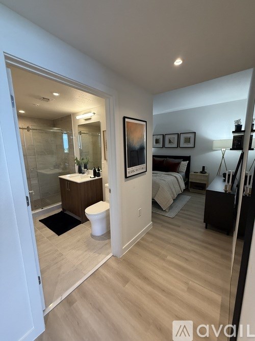 A bathroom with a toilet, sink, and mirror.